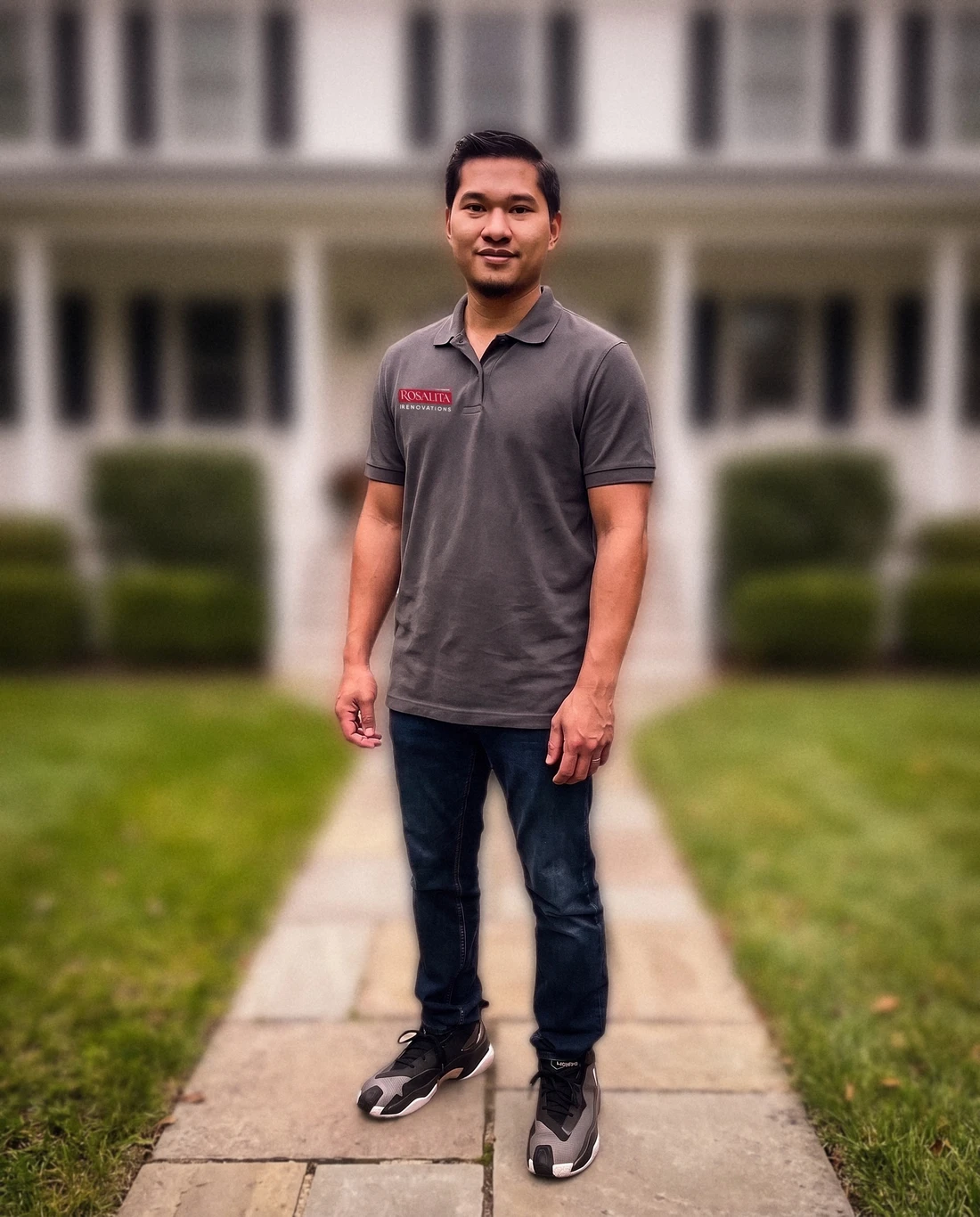 Francis Rosalita, owner of Rosalita Renovations, standing on the front walk of a white colonial home