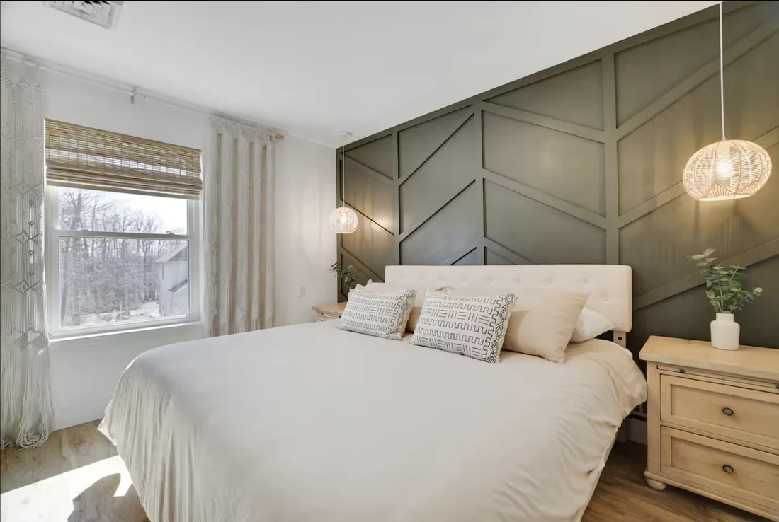 Bedroom with a dark green board-and-batten feature wall