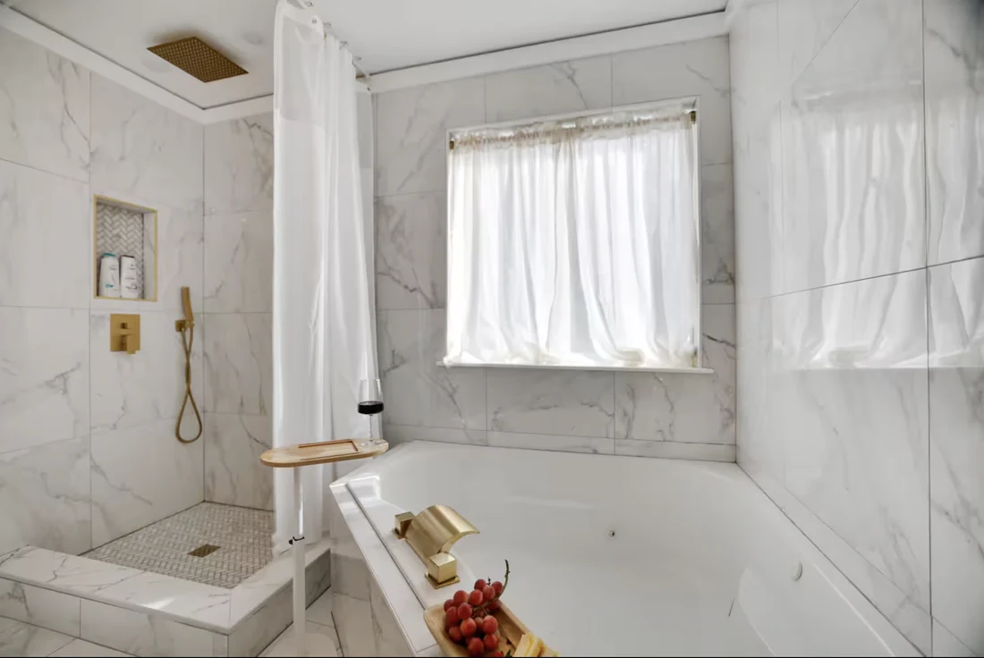 Primary bathroom tub set in marble-look tile